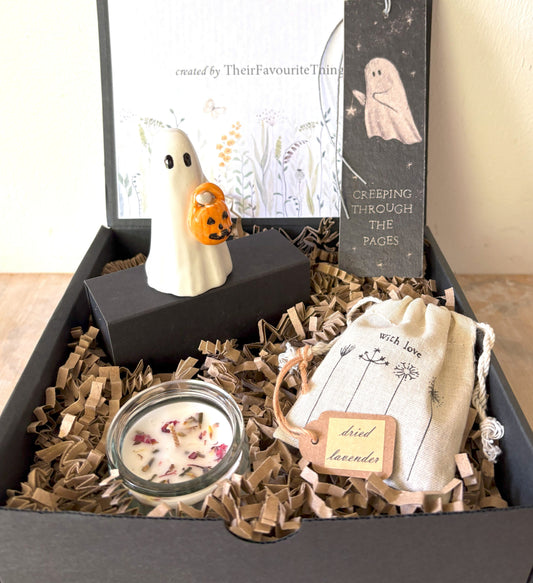 Gift box with Halloween-themed items including a ghost figurine, candle, and lavender bag.